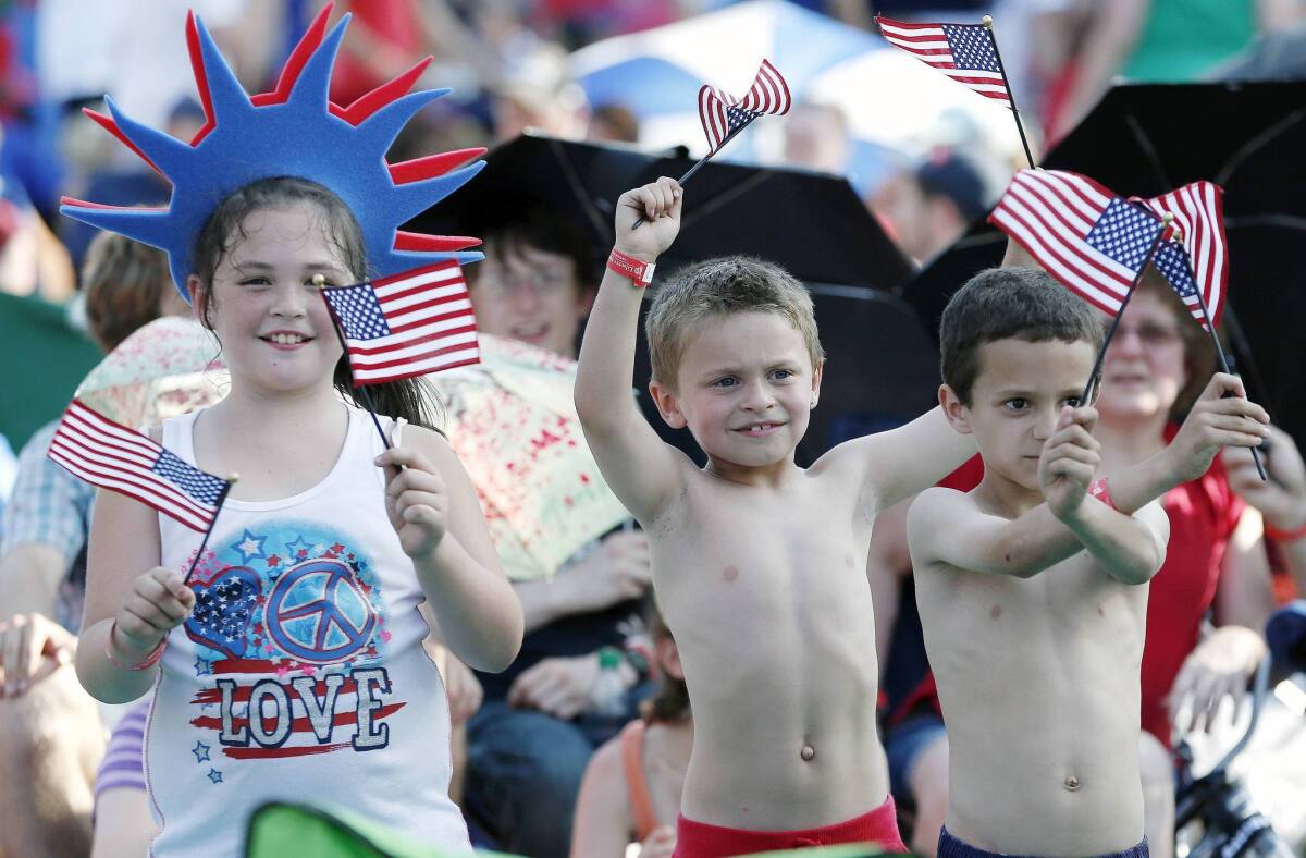Children celebrate the Fourth of July early on Thursday at the Esplanade in Boston. The annual Boston Pops Fourth of July concert was moved up a day because of potential heavy rain ahead of Hurricane Arthur.