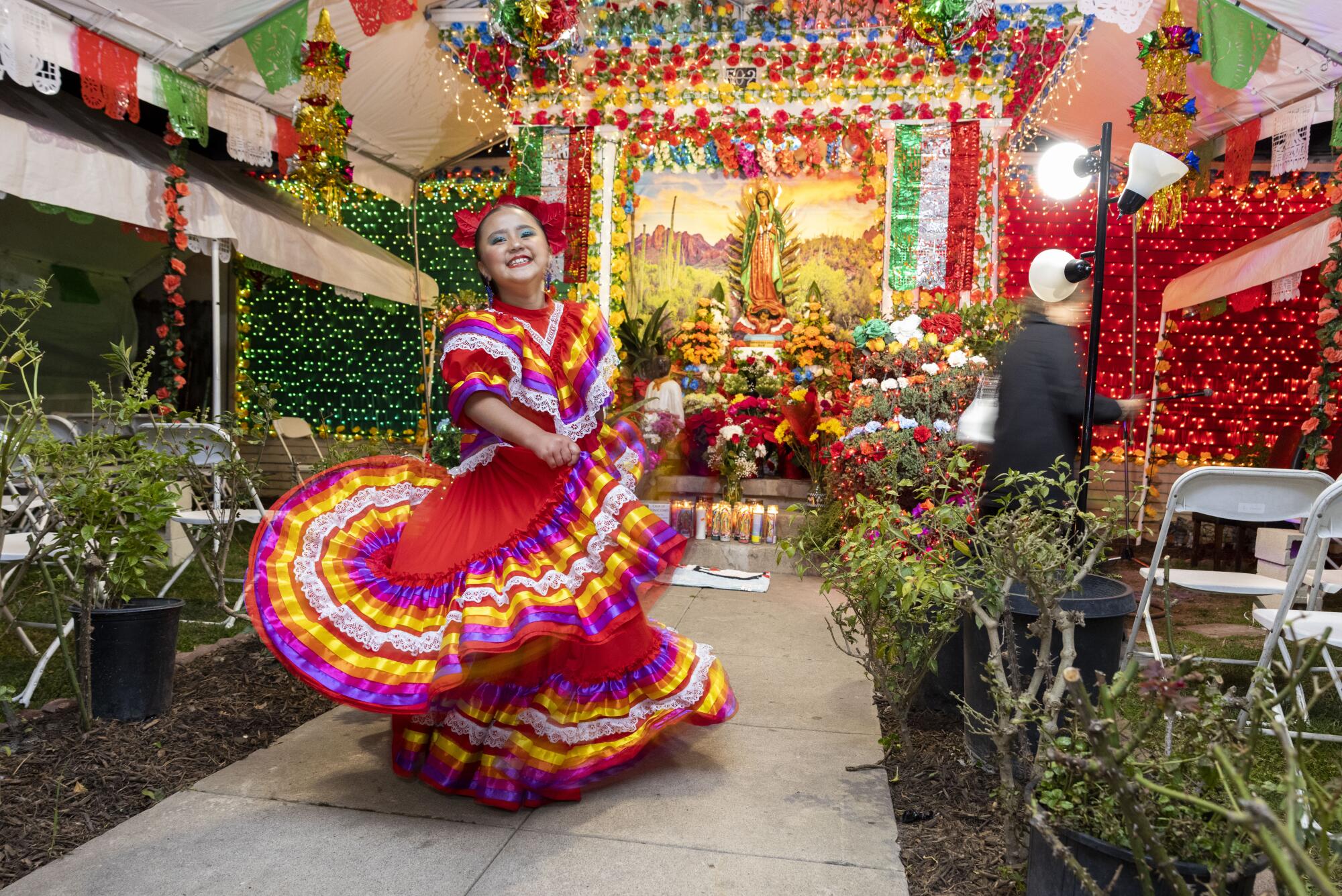 Santa Ana, CA- 7-year old Emily Navarro dances in front of an altar as part of celebration of the Virgen de Guadalupe day
