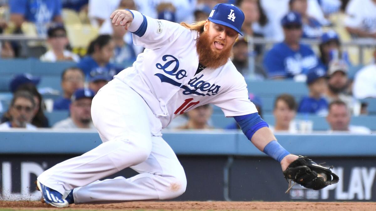 Dodgers third baseman Justin Turner mkaes a stop to throw out Cubs Addison Russell
