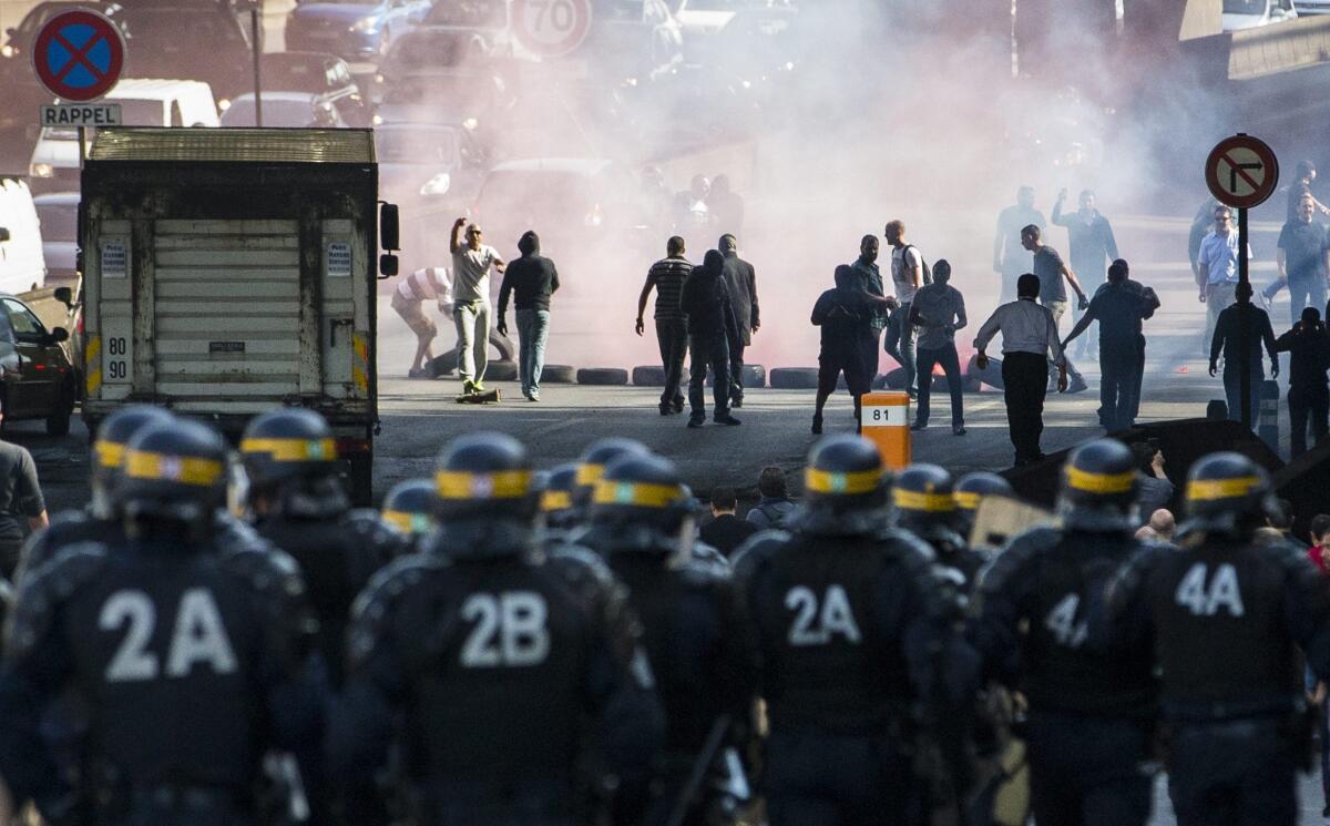French taxi drivers clash with riot police as they attempt to disrupt rush-hour traffic on the ring road around Paris during a demonstration against the Uber ride-share service.