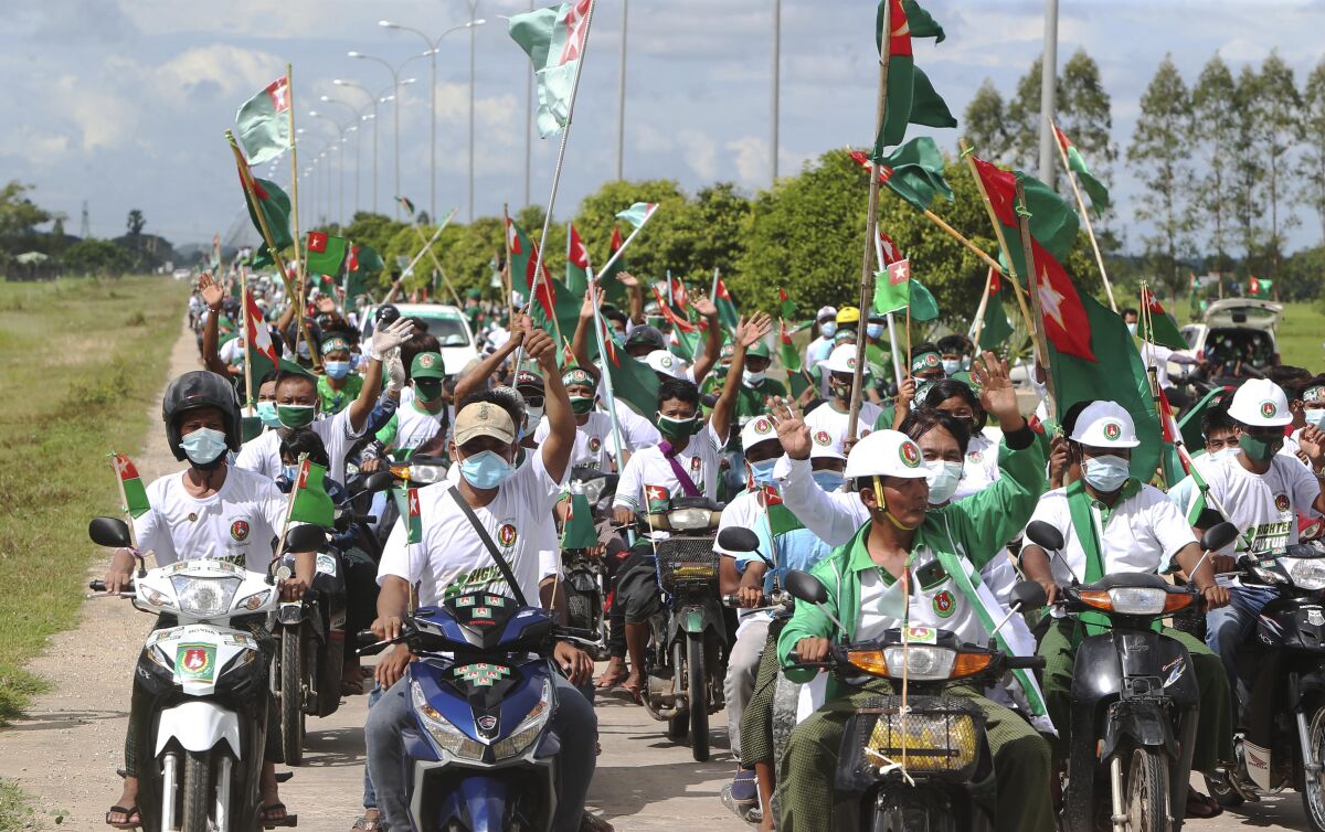 Supporters of the. military-backed Union Solidarity and Development Party (USDP) wave the party flags and cheer from their motorbikes during an election campaign for next month's general election, Thursday, Oct. 1, 2020, in Naypyitaw, Myanmar. (AP Photo/Aung Shine Oo)