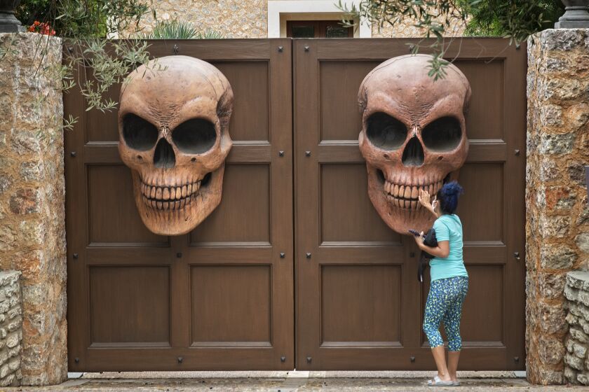BRENTWOOD, CA-OCTOBER 22, 2020: Liz Johnson of West L.A. gets a closer look at Halloween decorations at the entrance to a home on Crescenda St. in Brentwood. (Mel Melcon/Los Angeles Times)