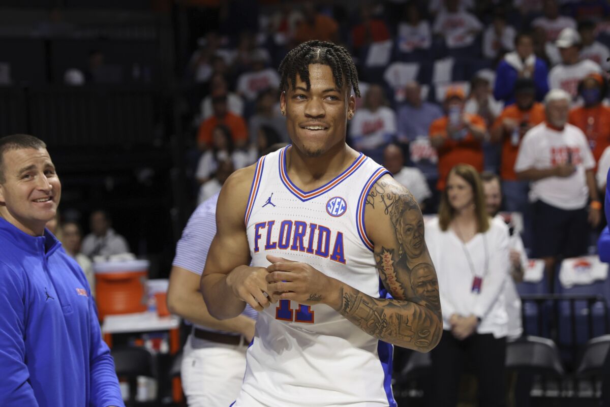 FILE - Florida forward Keyontae Johnson, center, smiles after being introduced as a starter before an NCAA college basketball game against Kentucky, March 5, 2022, in Gainesville, Fla. Johnson, who collapsed during a game in December 2020 and has not practiced or played since, has entered the NCAA transfer portal with hopes of resuming his college career. (AP Photo/Matt Stamey, File)
