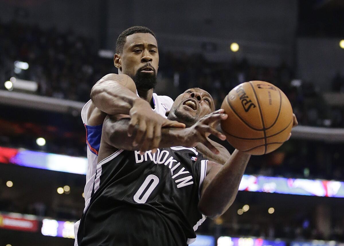Clippers center DeAndre Jordan, left, fouls Brooklyn's Andray Blatche while trying to block a shot during Saturday's 110-103 win. Jordan's vocal demeanor plays a role in his effort to become the NBA's top defender.