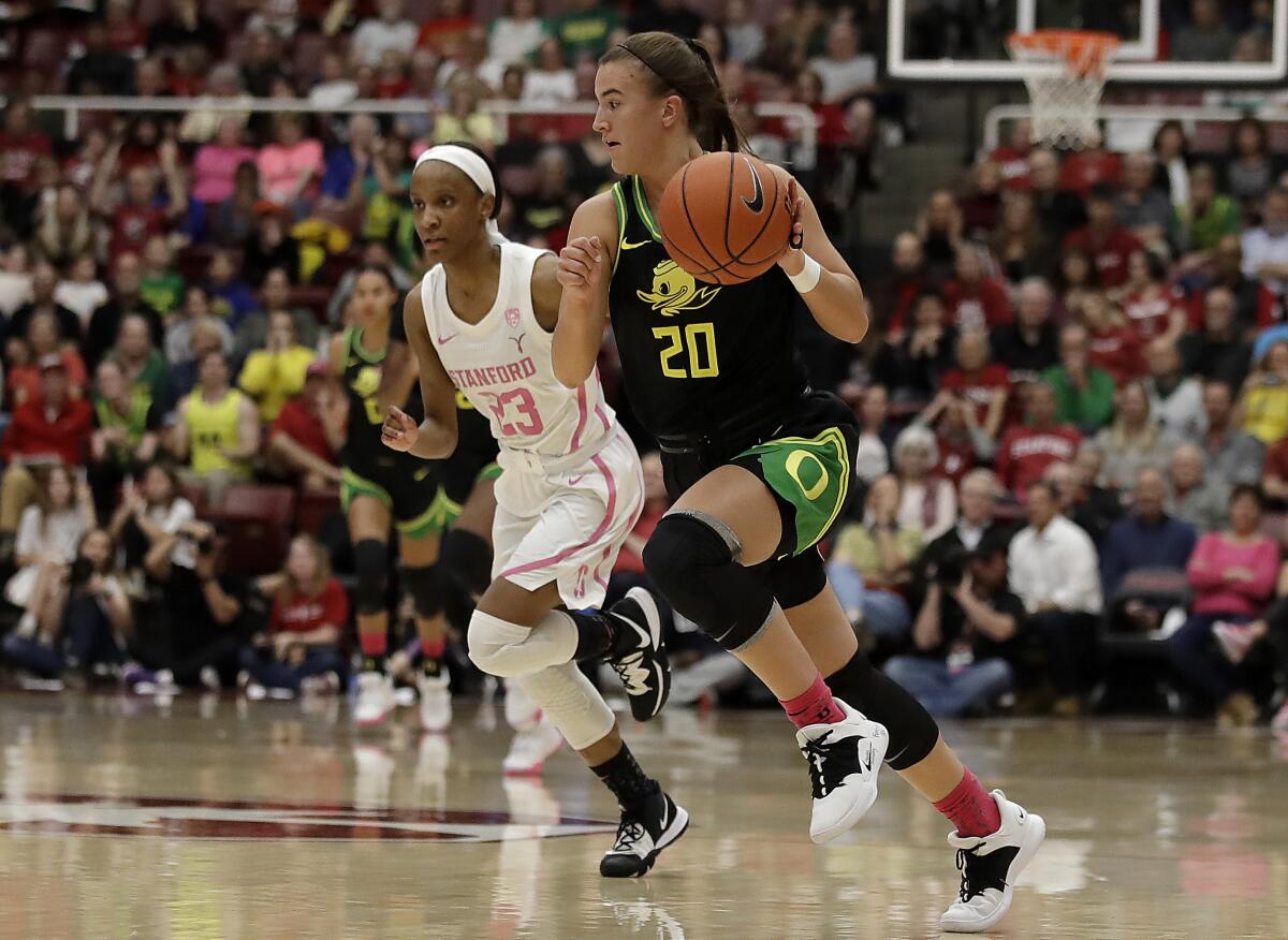 Oregon's Sabrina Ionescu drives the ball up court past Stanford's Kiana Williams. Ionescu became the first NCAA player to reach 2,000 points, 1,000 assists and 1,000 rebounds hours after speaking at Kobe Bryant's memorial.