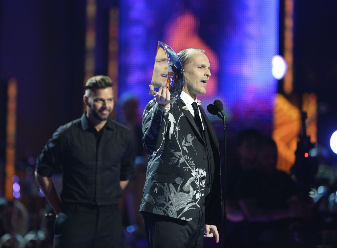 Italian-Spanish singer Miguel Bose, right, holds his 2013 Latin Recording Academy Person of the Year award presented by Puerto Rican singer Ricky Martin.