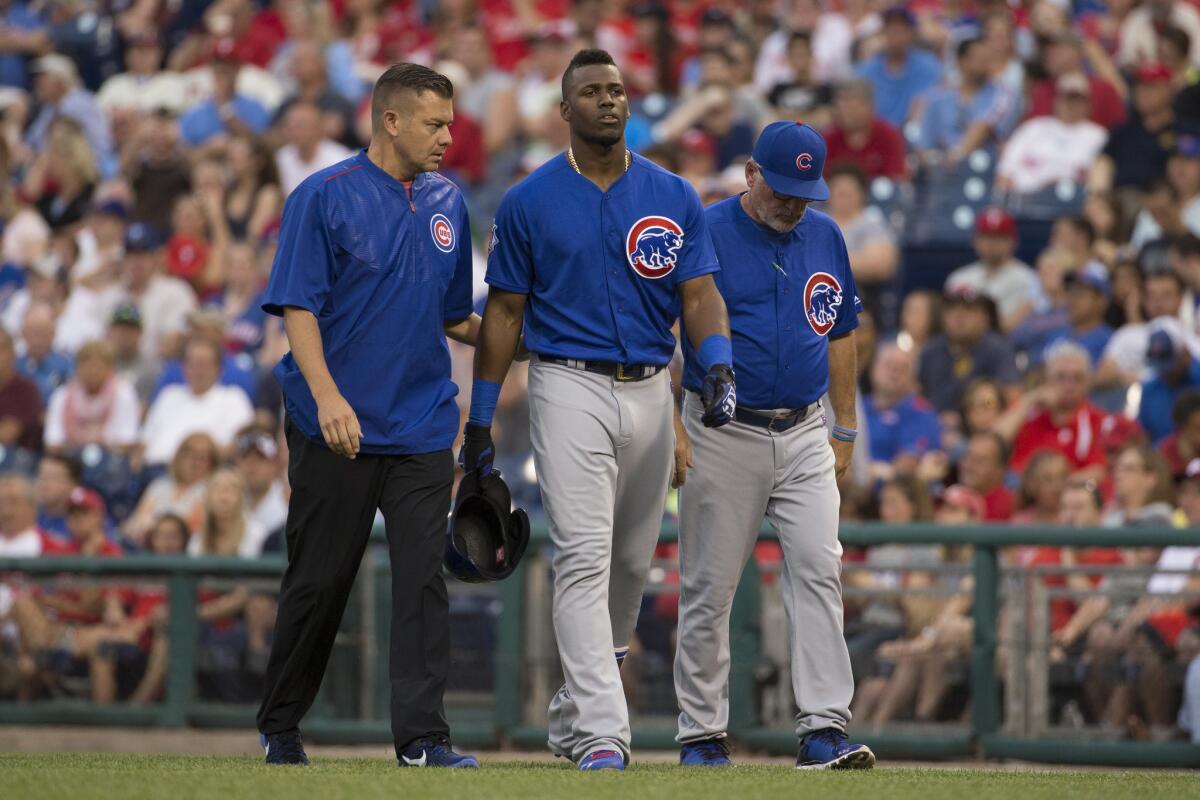 Cubs outfielder Jorge Soler, center, gets helped off the field by trainer P.J. Mainville, left, and Manager Joe Maddon, right, during the third inning on June 6.