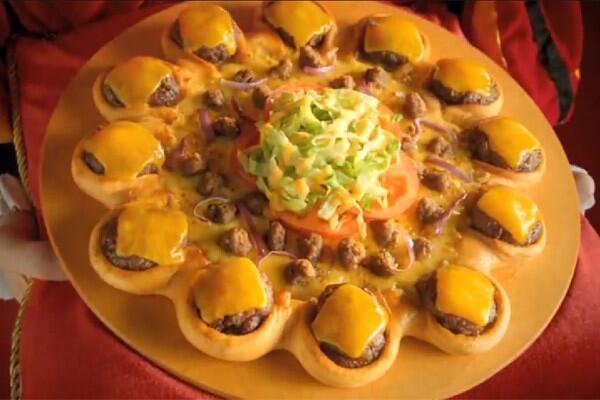 It looks like a standard meat-laden pizza but topped with the accouterments of a taco and ringed with mini burgers dripping with melted cheese. More: Cheeseburger-ringed pizza debuts -- in the Middle East