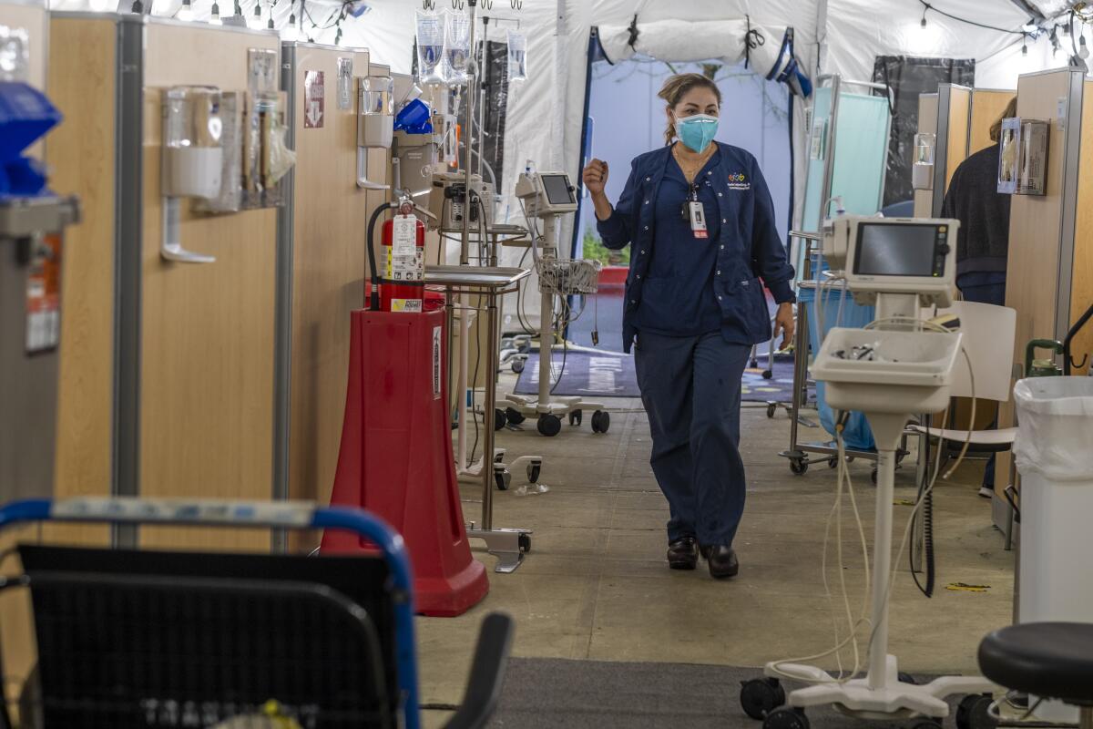 A nurse walks inside a hospital respiratory tent.