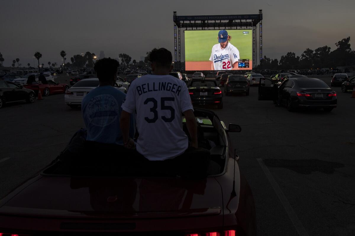 Dodgers fans sit on the back seat of their convertible while watching Game 1 of the World Series.