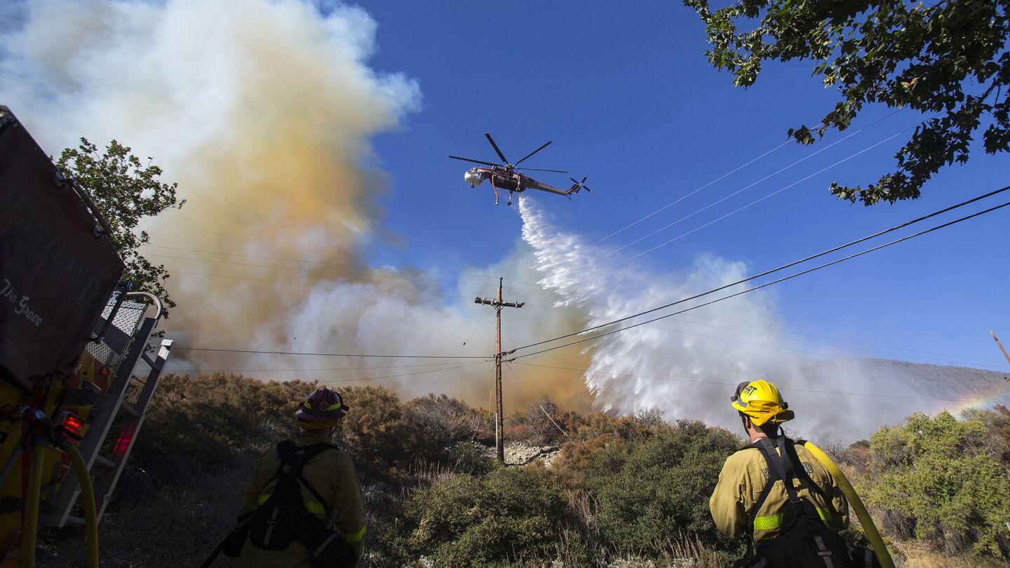 A sky crane drops water on the Blue Cut Fire to keep it from crossing Lytle Creek Road on Wednesday in Lytle Creek.