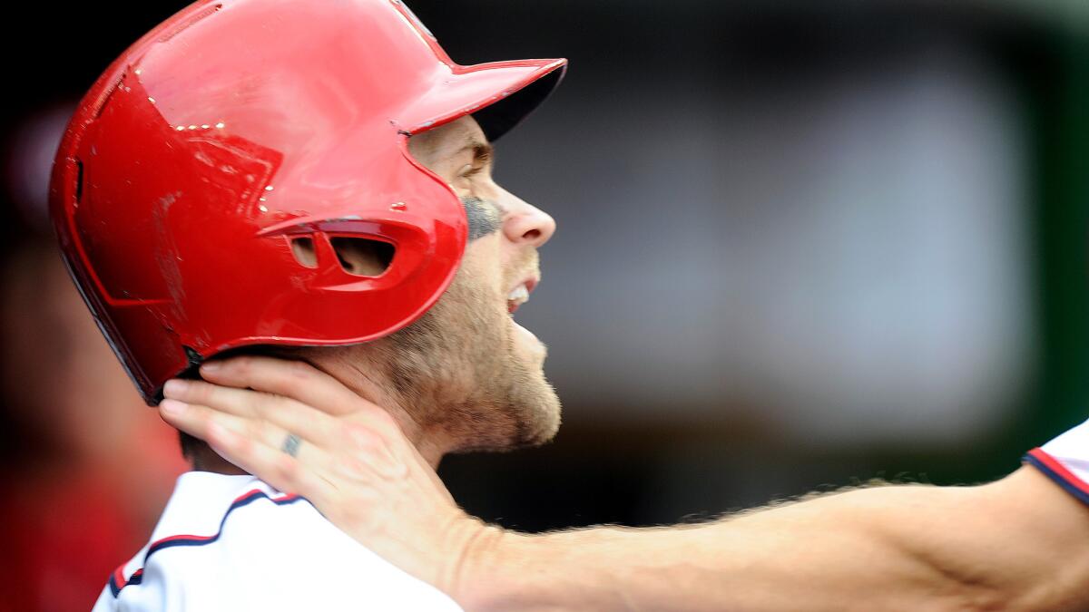 Nationals outfielder Bryce Harper is grabbed by Jonathan Papelbon in the dugout during the eighth inning of their game Sunday in Washington.