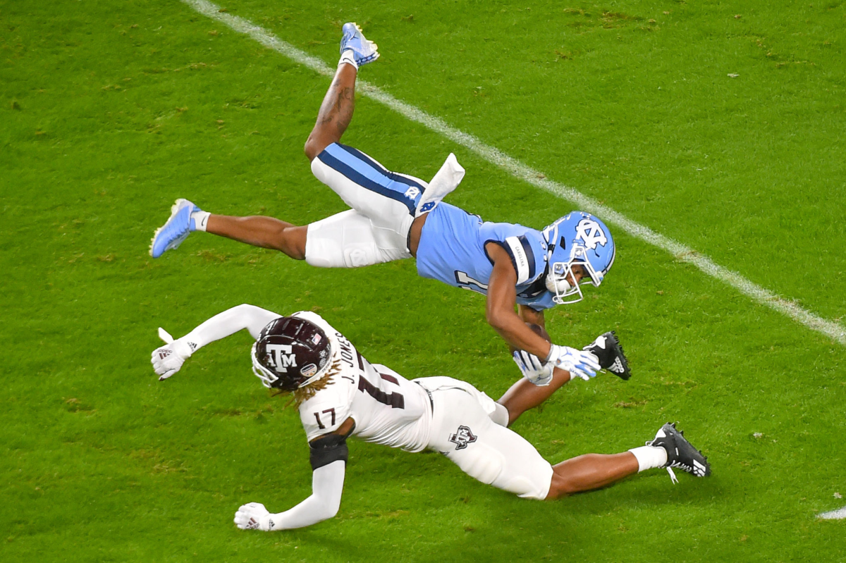 North Carolina's Josh Downs is upended by Texas A&M's Jaylon Jones during the Orange Bowl on Jan. 2, 2021.