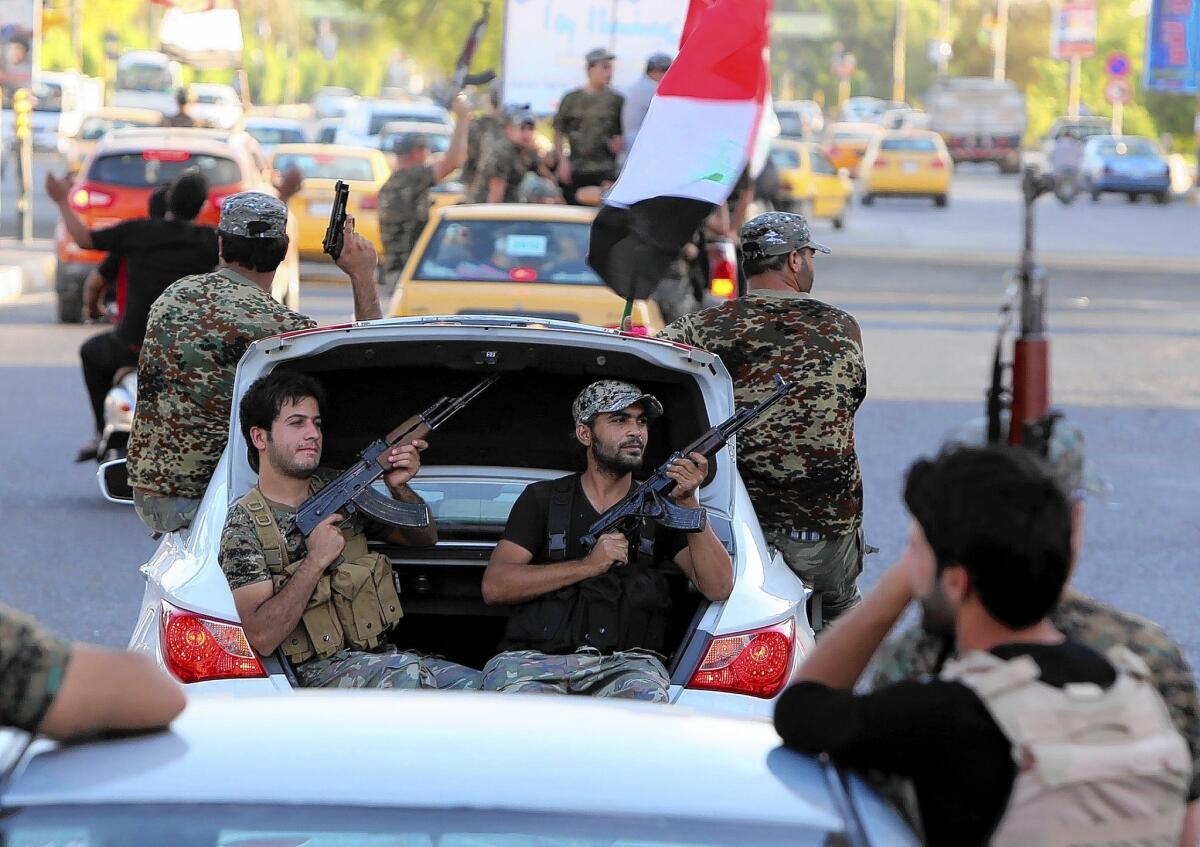 Shiite Muslims parade with their weapons in central Baghdad to show their willingness to join the Iraqi security forces in the fight against Islamic militants.