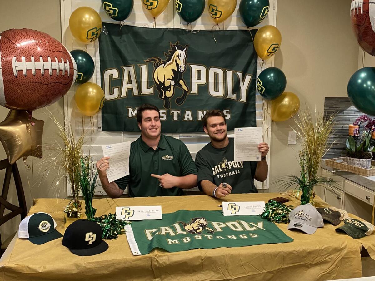 Corona del Mar High seniors Jake Trachtman and Thomas Bouda celebrate signing with Cal Poly San Luis Obispo on Wednesday.