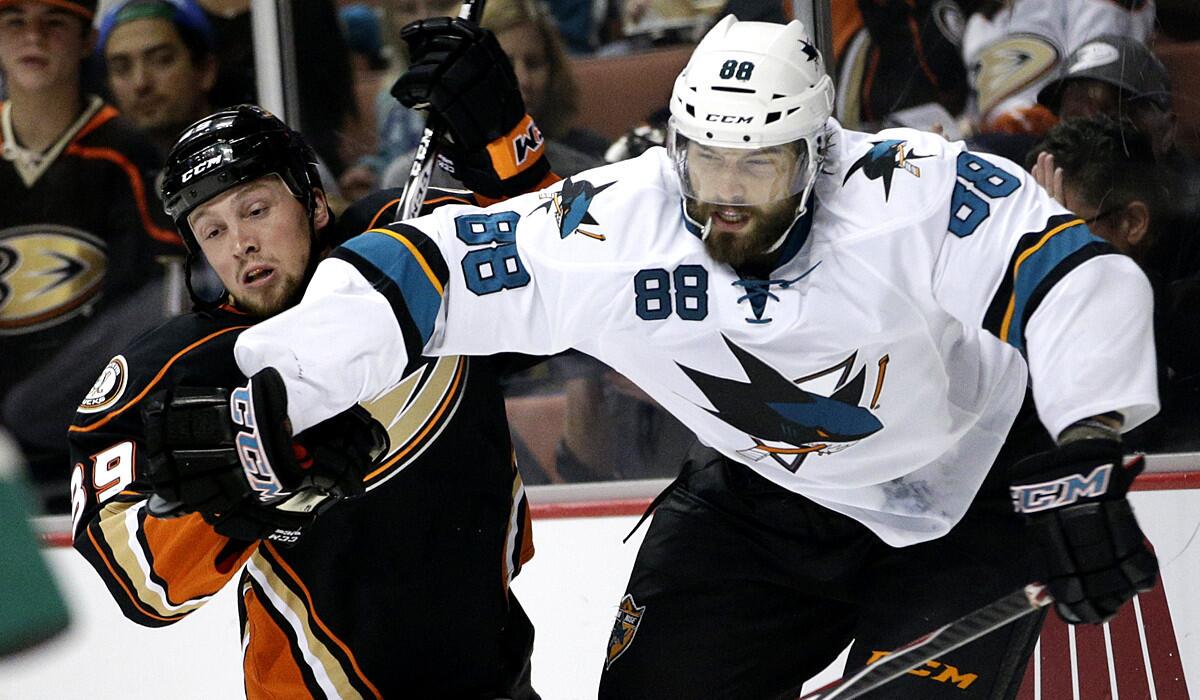 Ducks left wing Matt Beleskey (39) and Sharks right wing Brent Burns (88) battle for the puck behind the net in the second period Sunday in Anaheim.