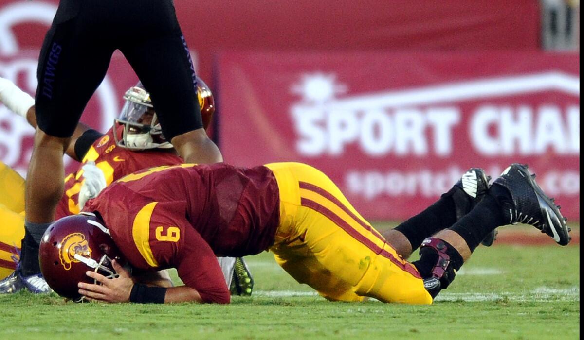 USC quarterback Cody Kessler holds his head after giving up his second interception against Washington on Thursday.