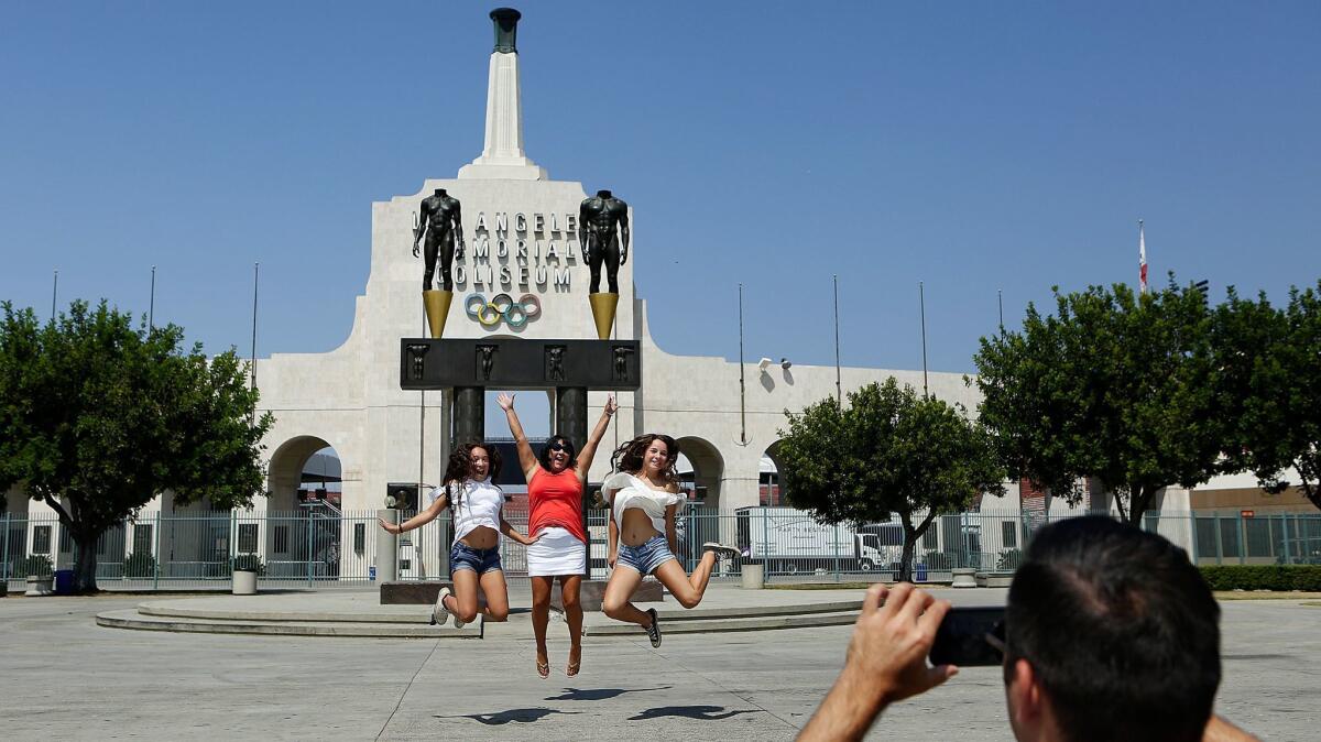 Visitors take pictures outside the Los Angeles Memorial Coliseum.