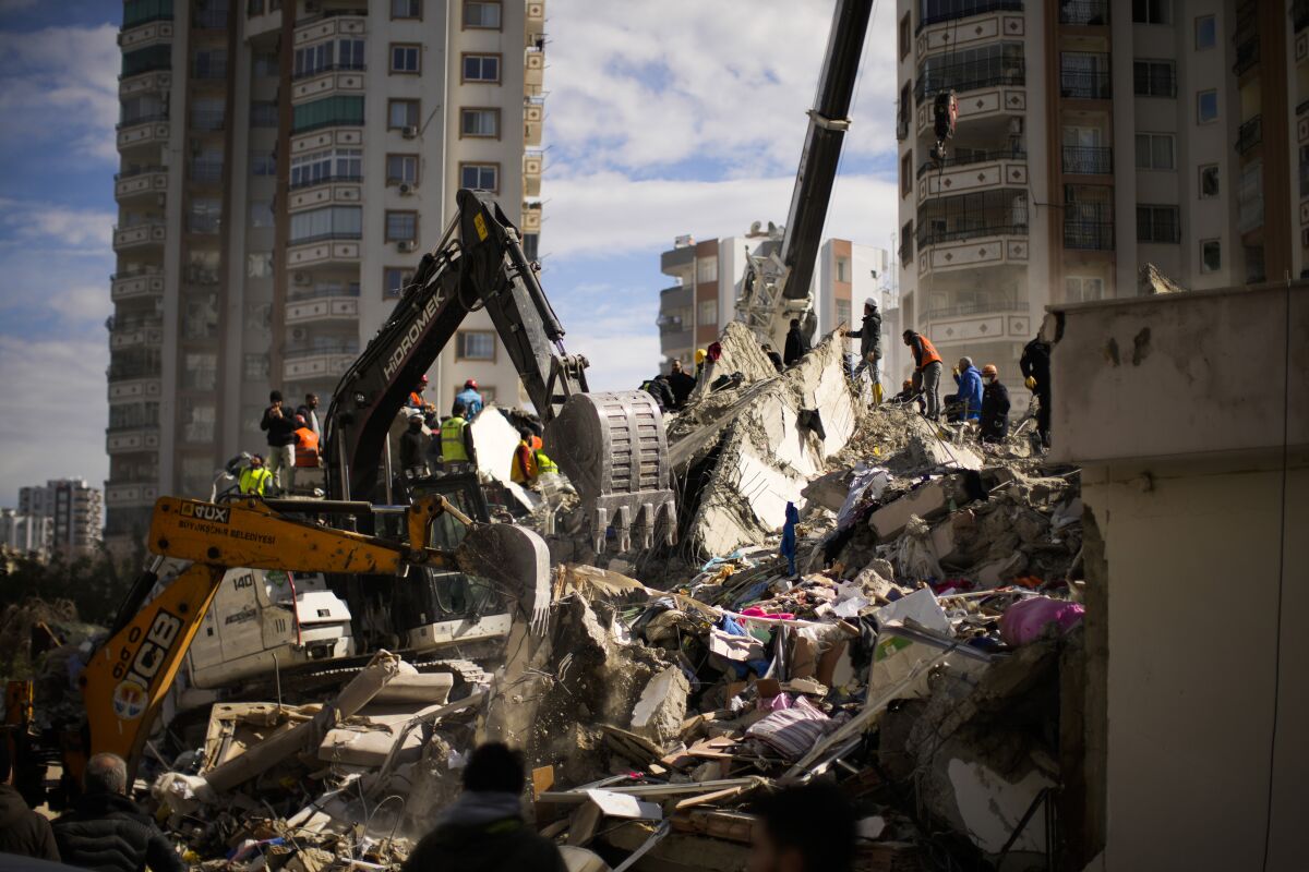 Emergency workers searching for people in a destroyed building in Adana, Turkey