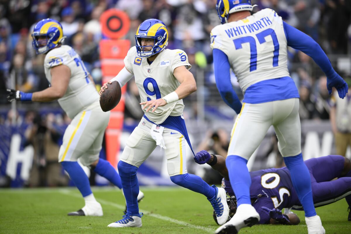 Los Angeles Rams quarterback Matthew Stafford (9) avoids a sack attempt by Baltimore Ravens outside linebacker Justin Houston (50) during the first half of an NFL football game, Sunday, Jan. 2, 2022, in Baltimore. (AP Photo/Nick Wass)