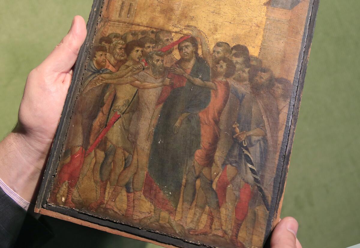  The image shows the hands of an art historian holding a small tempera and gold leaf painting on panel by the 13th-century Italian master painter Cimabue.