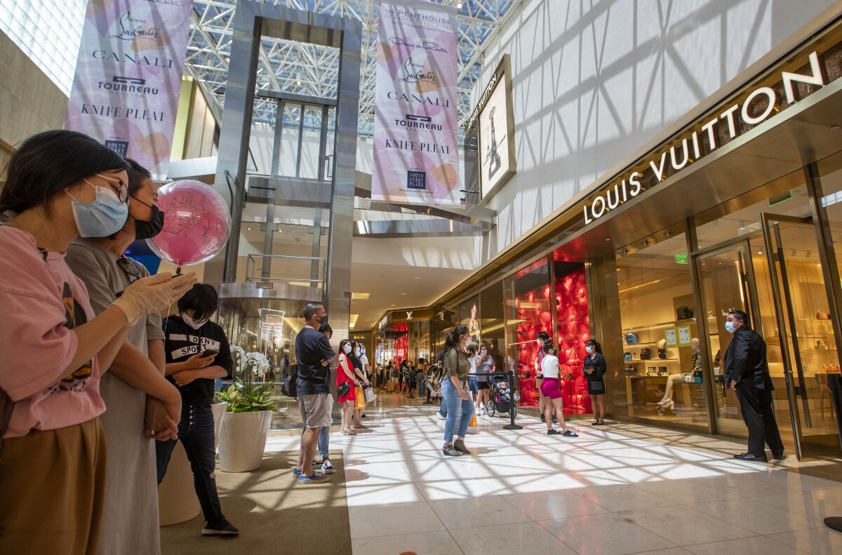 Shoppers follow social-distancing etiquette outside a Louis Vuitton store at South Coast Plaza on June 11.
