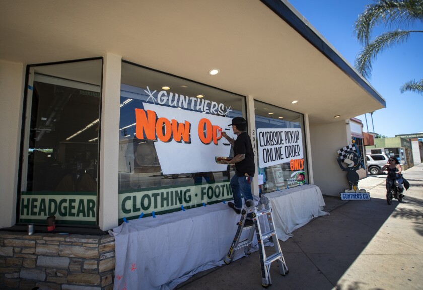 Akihiro Tsuneizumi paints a window sign at Gunther's in Santa Ana.
