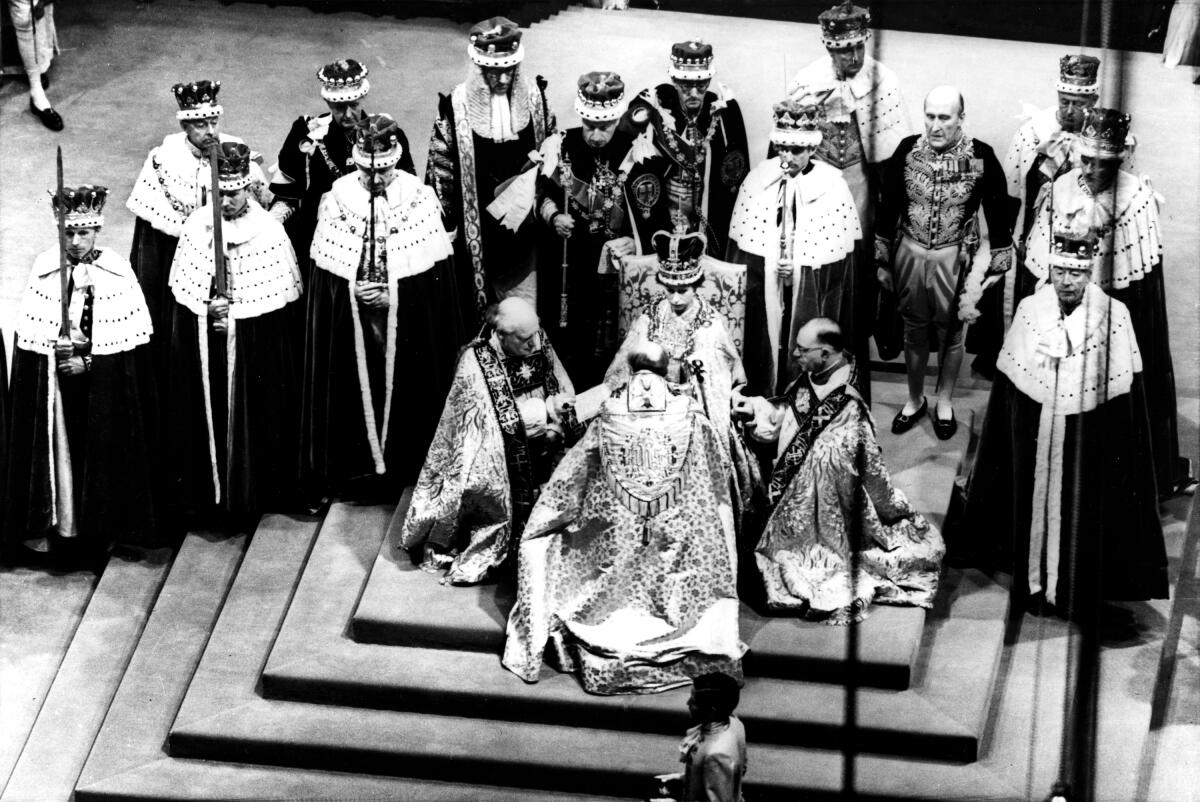 Britain's Queen Elizabeth II, seated on the throne, receives the fealty of the Archbishop of Canterbury,