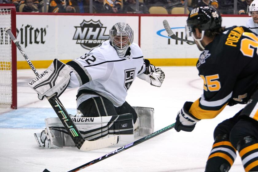 Los Angeles Kings goaltender Jonathan Quick (32) blocks a shot attempt by Pittsburgh Penguins' Ryan Poehling (25) during the second period of an NHL hockey game in Pittsburgh, Thursday, Oct. 20, 2022. (AP Photo/Gene J. Puskar)