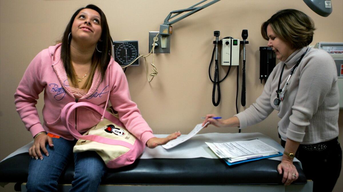 A teen with type 2 diabetes hands her blood sugar report to her doctor at Children's Hospital in Los Angeles. (Gina Ferazzi / Los Angeles Times)