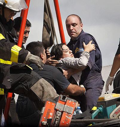 An injured passenger is lifted from wreckage by firefighters at Once train station. The city emergency service confirmed so far 550 injured and at least 40 deaths when a suburban train failed to brake and ran into the buffers at the railway terminus.