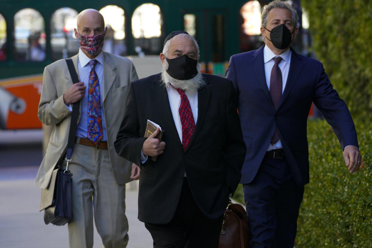 Yisroel Goldstein, flanked by his attorneys, walks to court