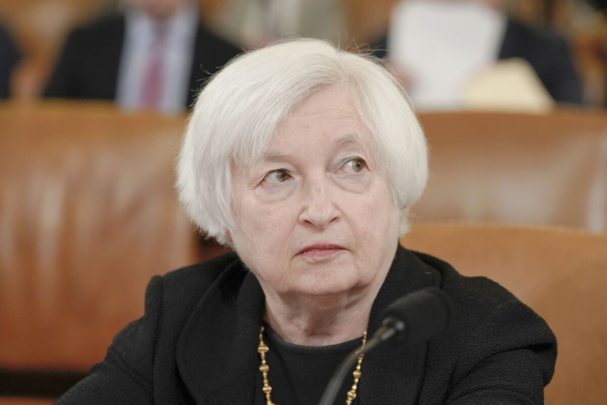 Treasury Secretary Janet Yellen listens and looks to her left while seated.