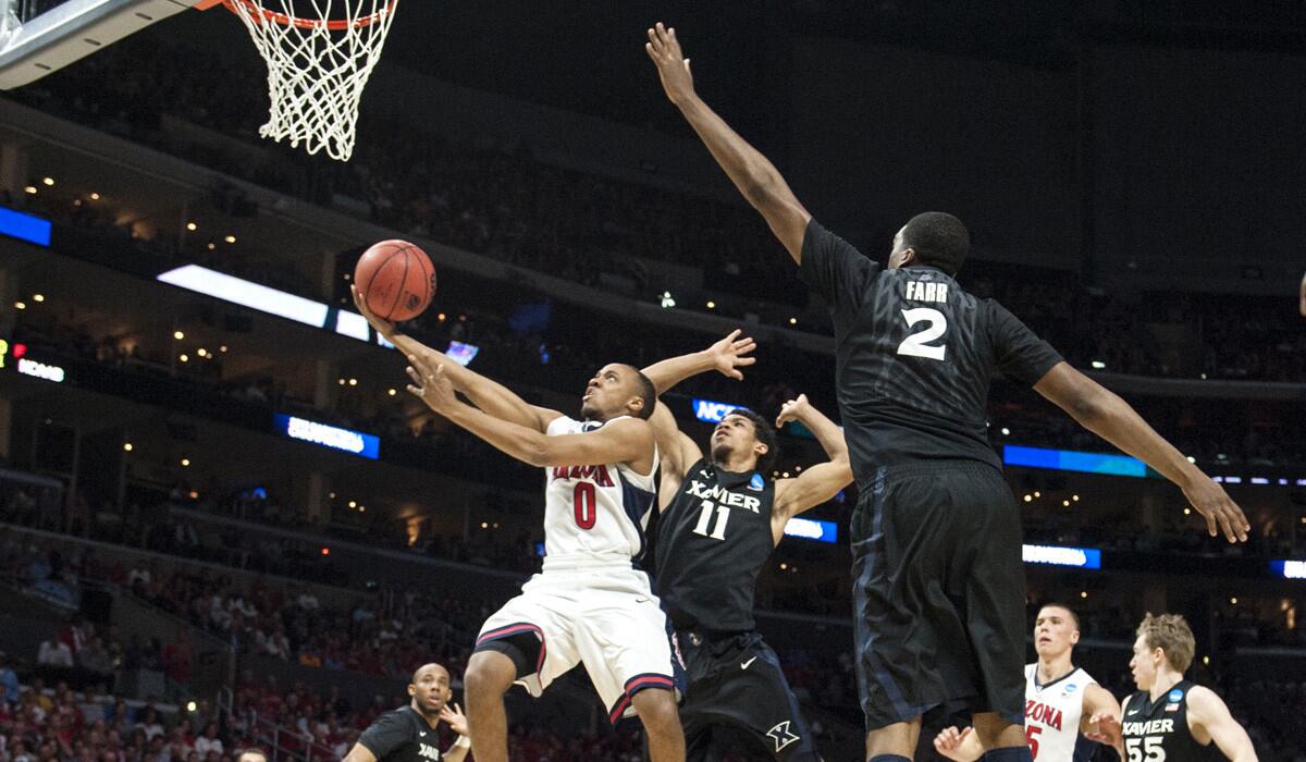 Arizona Wildcats guard Parker Jackson-Cartwright drives by Xavier Musketeers guard Dee Davis during the Wildcats', 68-30, win over the Musketeers in the NCAA West Region semifinals at Staples Center on Thursday.