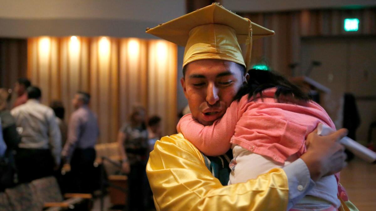 Bryan Peña, 18, celebrates with family after graduating from high school. Peña benefits from protections under the Deferred Action for Childhood Arrivals program.