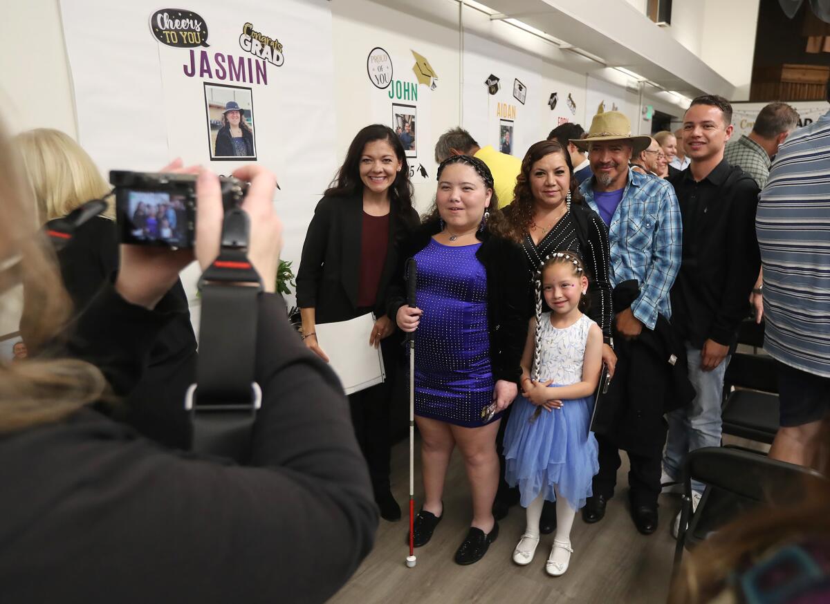 Jasmin Garcilazo, in blue, stands with her family after graduating.