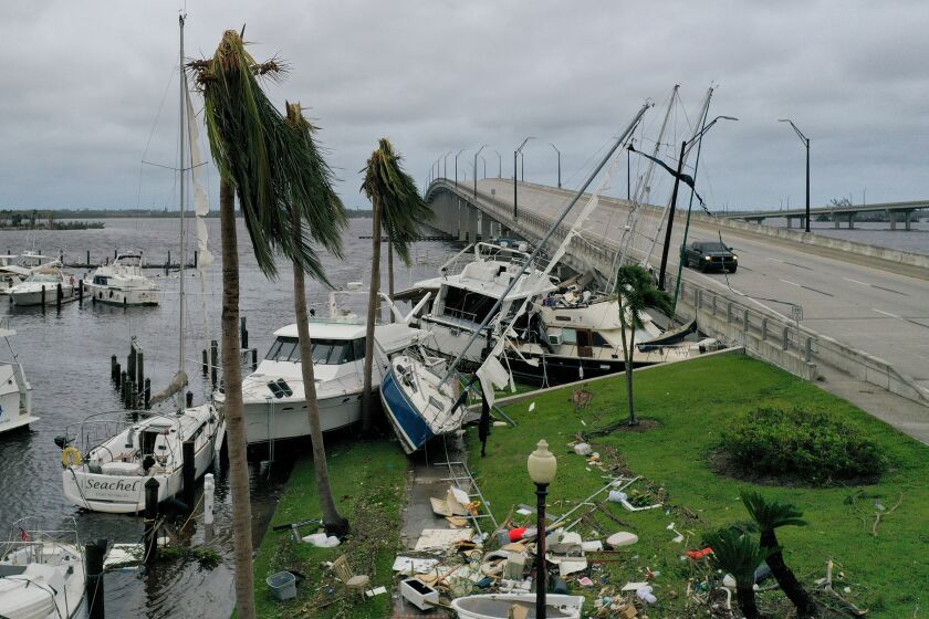 Boats are pushed up on a causeway after Hurricane Ian passed through Fort Myers, Florida.