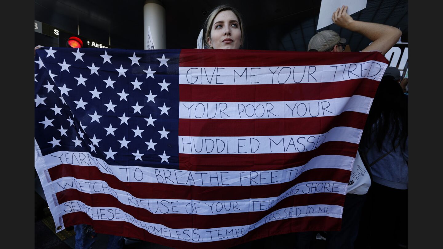 Chella, from Sherman Oaks, holds the U.S. flag with words from the tablet on the Statue of Liberty.