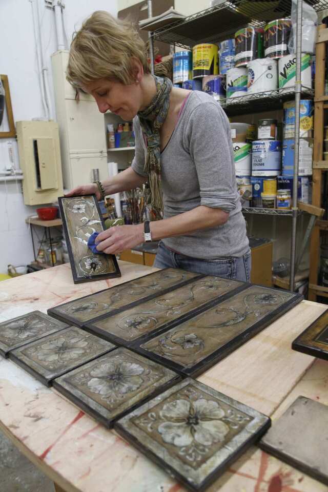 Furniture restorer and decorative painter Jacqueline Moore was so intrigued by the Malibu tiles she saw at the Montecito garden Lotusland she was inspired to craft tile in her medium: wood. She's pictured here in her Santa Monica studio.