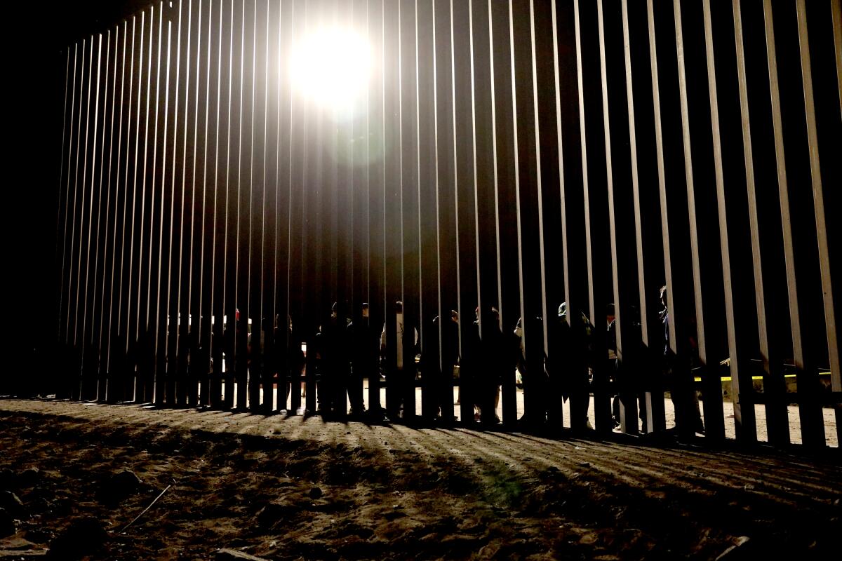 People stand at the U.S.-Mexico border in Somerton, Ariz., in May 2023.