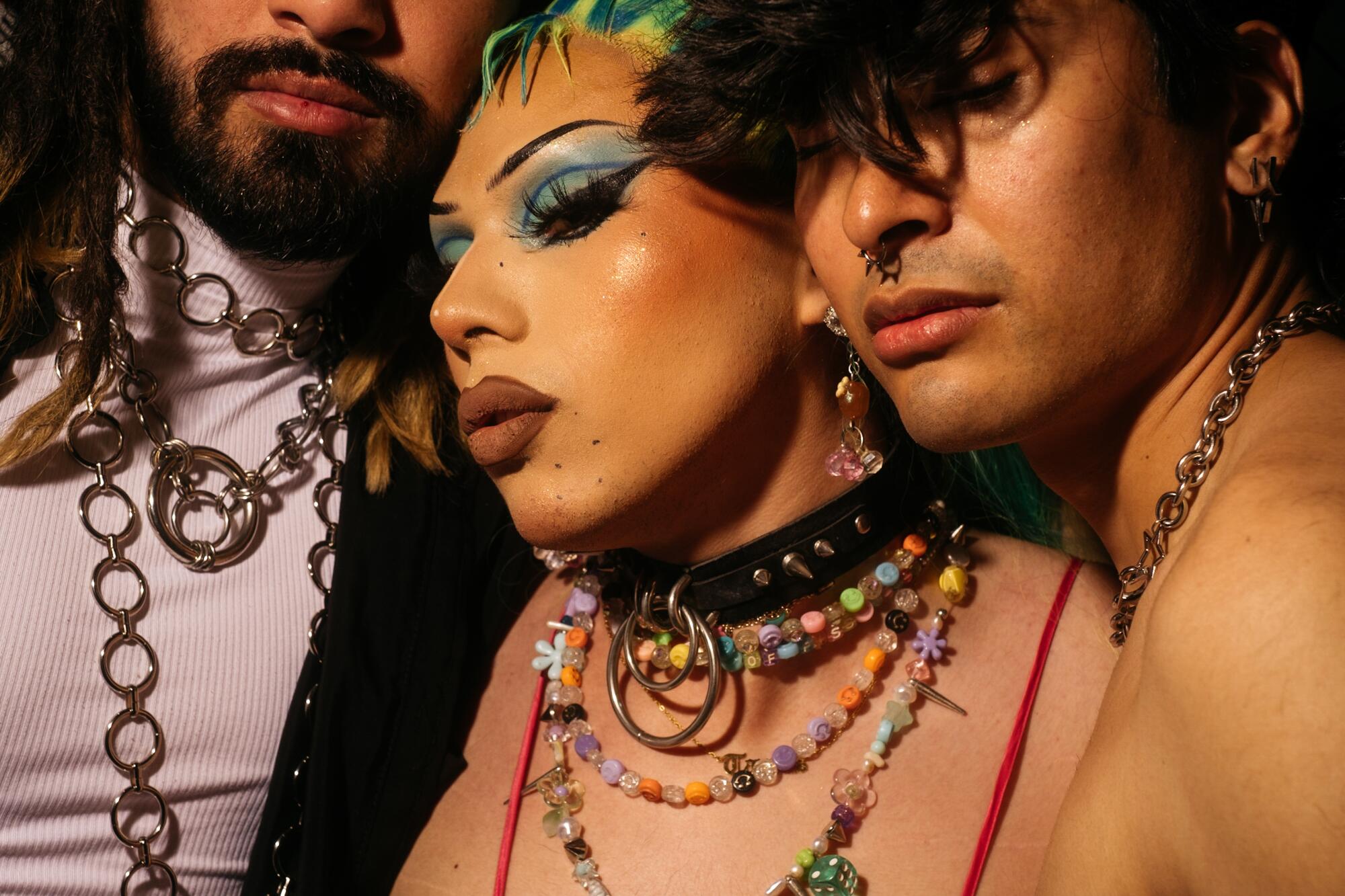A close up of three people wearing jewelry and makeup.