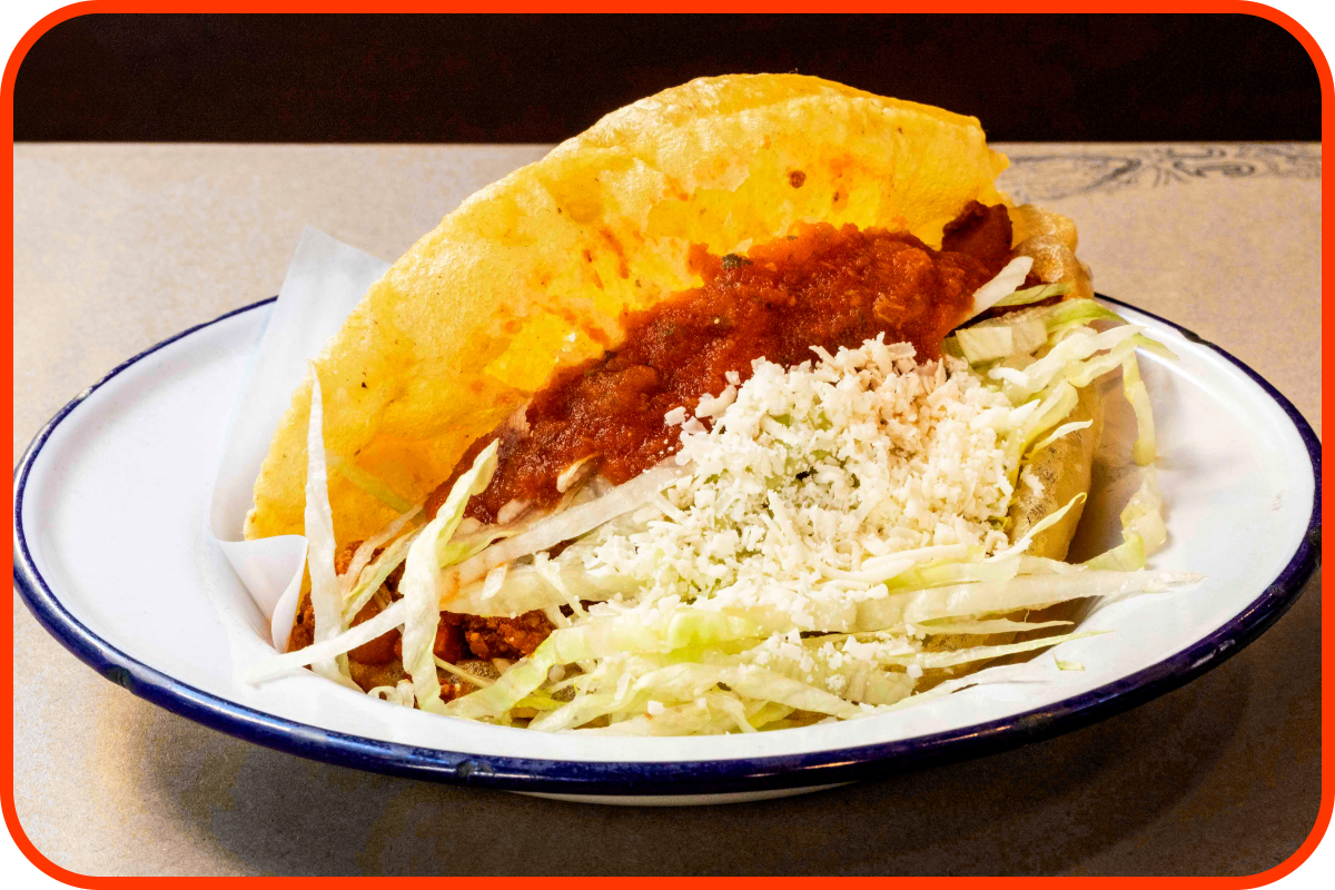 Puffy Taco with picadillo chicken, salsa and queso fresco.