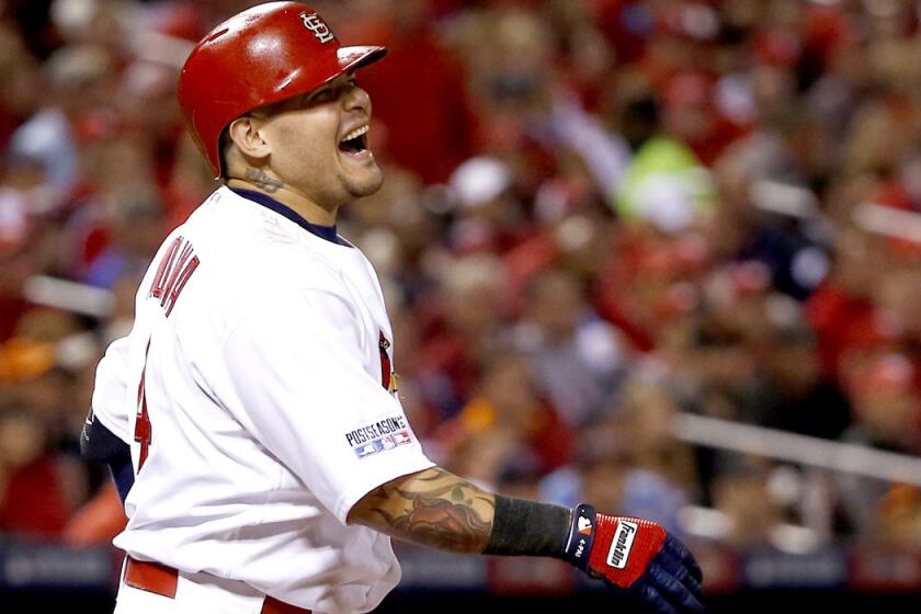 Cardinals catcher Yadier Molina grimaces after straining his left oblique muscle while taking a swing in Game 2 of the NLCS on Sunday in St. Louis.