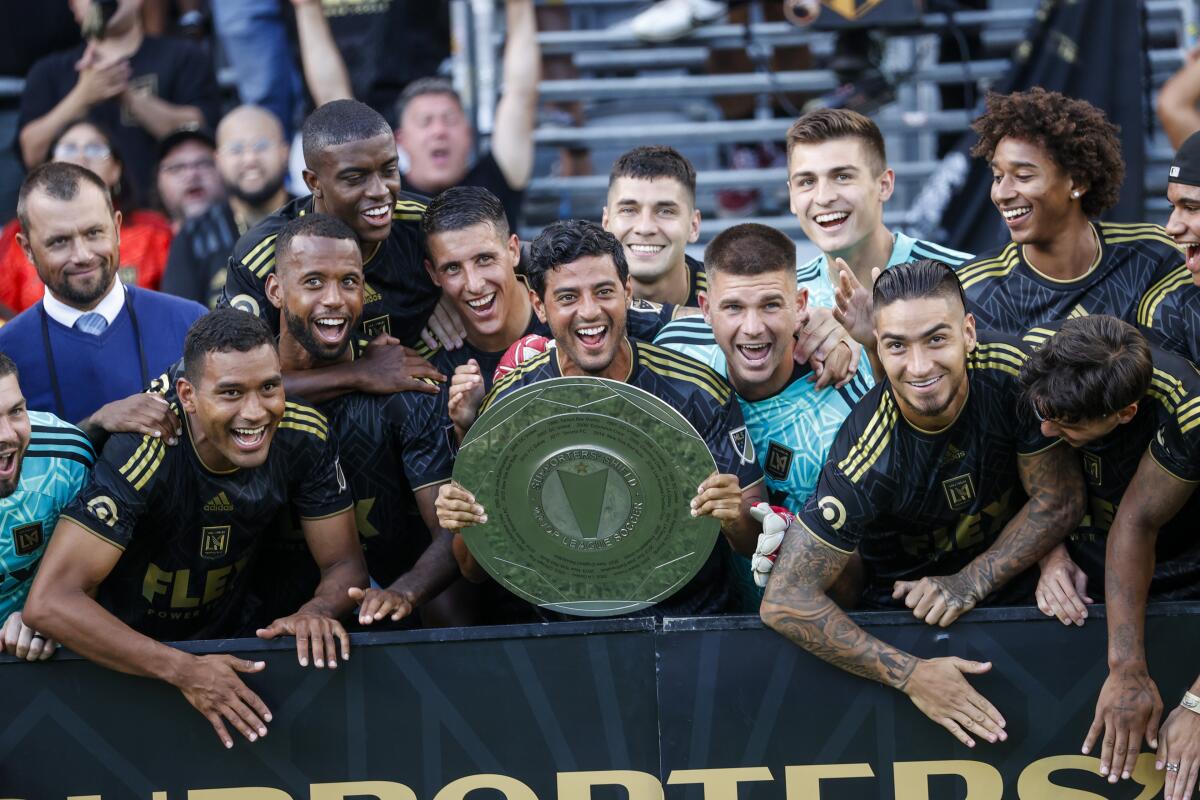 Los Angeles FC players celebrate with the Supporters' Shield trophy after a match against Nashville SC.
