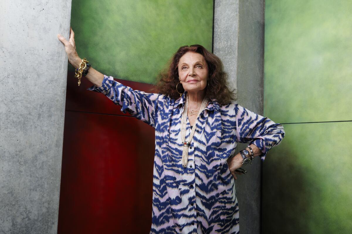 Diane von Furstenberg berdiri dan menyandarkan tangannya ke dinding berwarna-warni