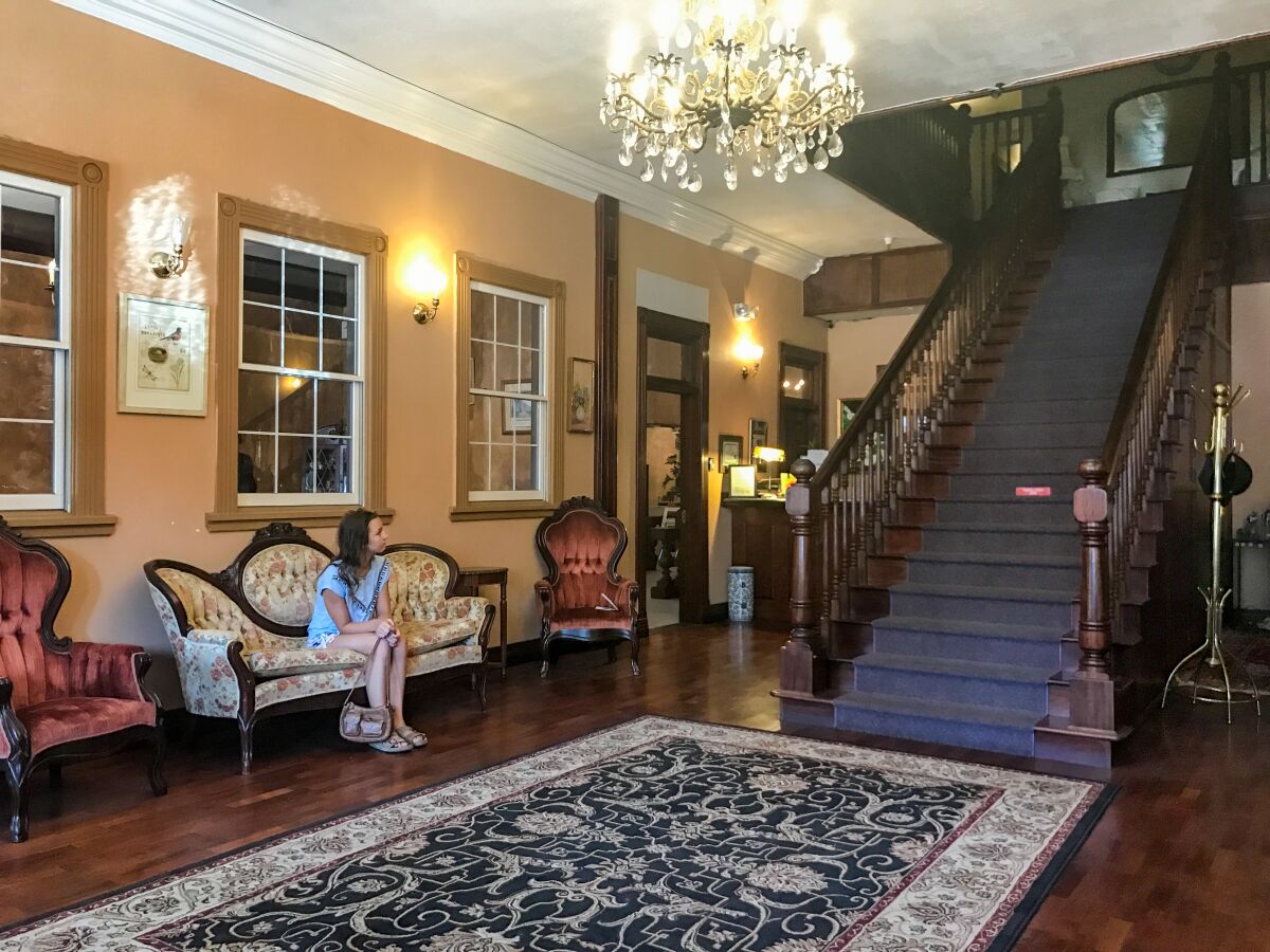 The Ione Hotel's lobby features a chandelier, antique furniture and mahogany staircase.