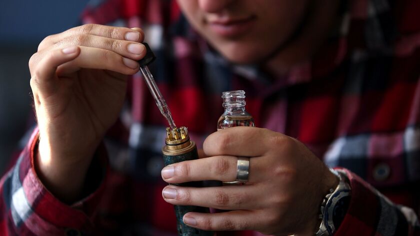 A customer fills an electronic cigarette with liquid at a vaping shop in San Rafael, Calif. A new report finds that e-cigarette use fell among high school students in 2016, the first such decline since researchers began keeping track.