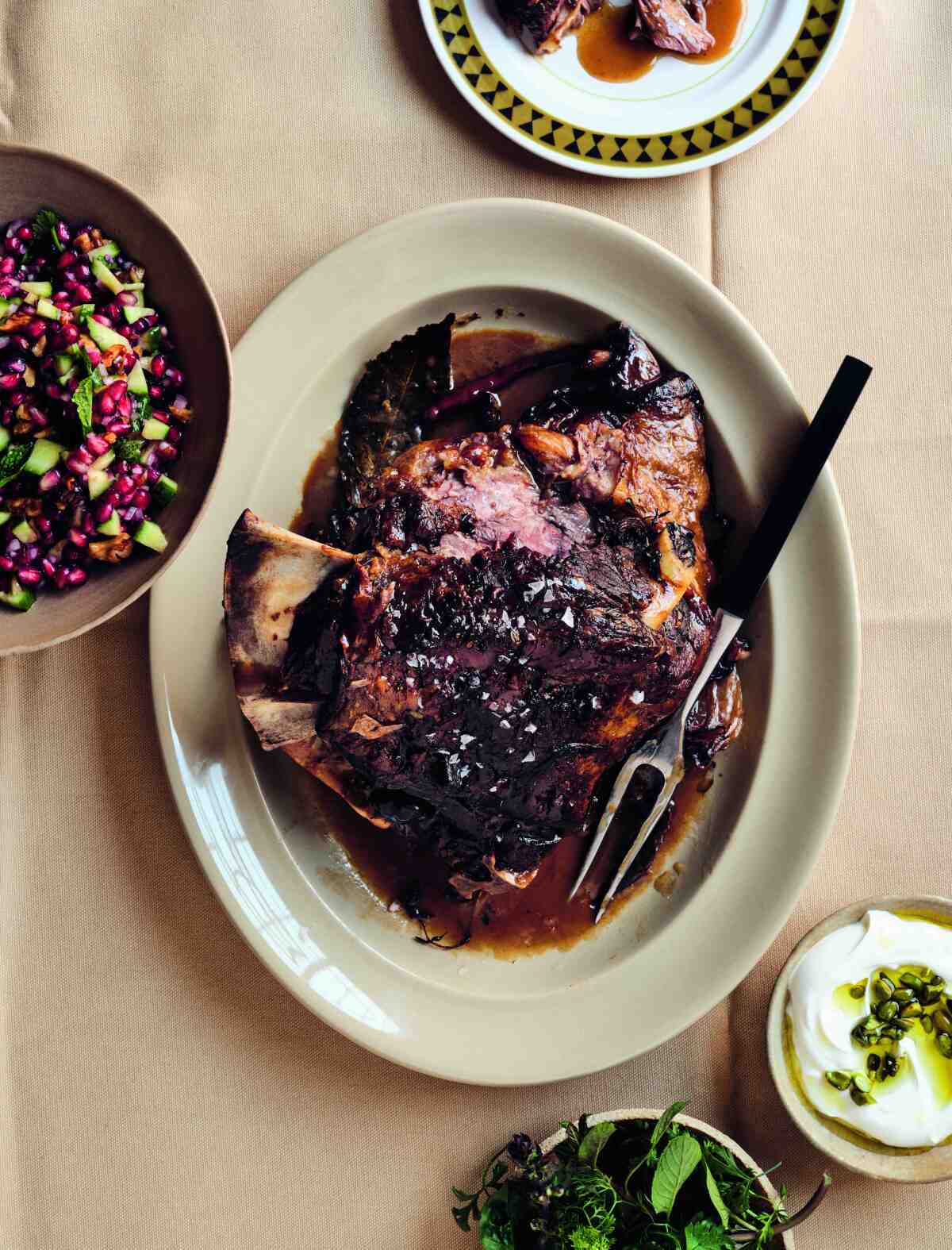 Closeup of a plate of meat with a carving fork.