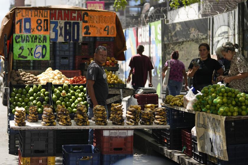 Un vendedor mira desde su puesto de productos agrícolas en Caracas, Venezuela, el miércoles 24 de julio de 2024. Los votantes acudirán a las urnas el 28 de julio para las elecciones presidenciales. (Foto AP/Fernando Vergara)
