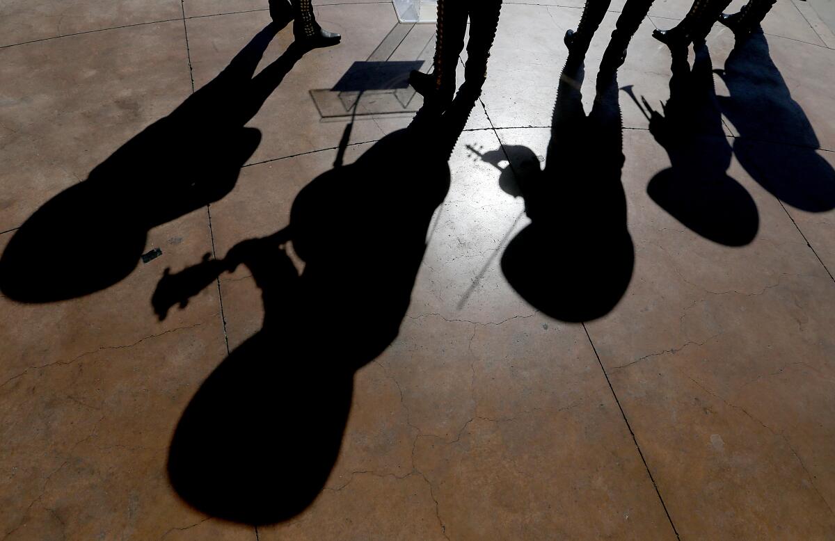 A mariachi band casts shadows on Mariachi Plaza earlier this month. 